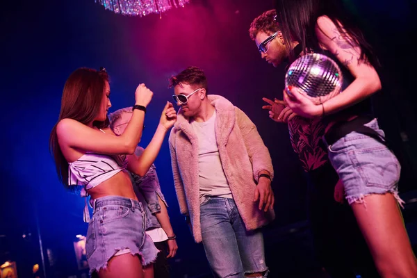 Gençler gece kulübünde renkli lazer ışıklarıyla eğleniyorlar..