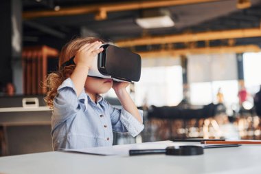 Sanal gerçeklik gözlüklü çocuk ve günlük giysiler içinde oyun odasında iyi eğlenceler..