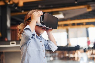 Sanal gerçeklik gözlüklü çocuk ve günlük giysiler içinde oyun odasında iyi eğlenceler..