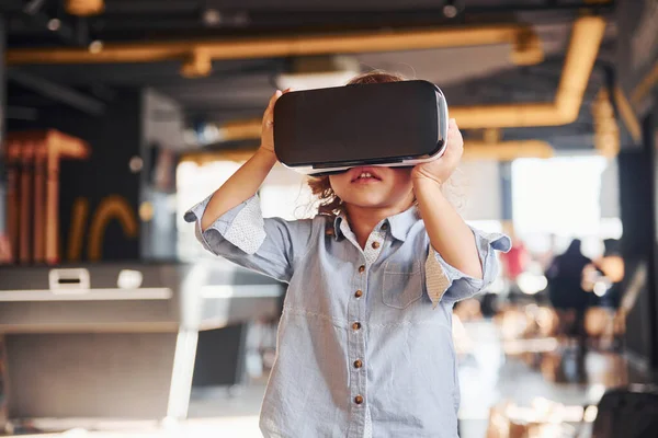 Sanal gerçeklik gözlüklü çocuk ve günlük giysiler içinde oyun odasında iyi eğlenceler..