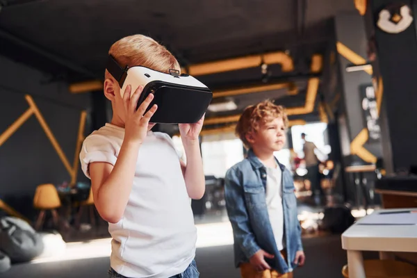 Sanal gerçeklik gözlüklü çocuk ve günlük giysiler içinde oyun odasında iyi eğlenceler..