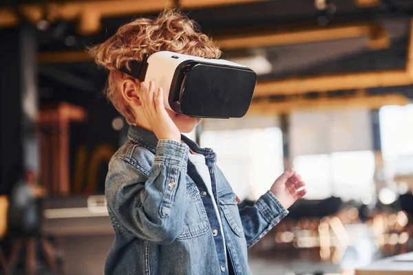 Sanal gerçeklik gözlüklü çocuk ve günlük giysiler içinde oyun odasında iyi eğlenceler..