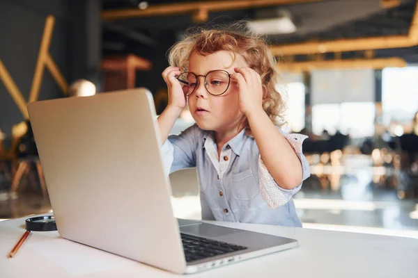 Stock image Smart child in casual clothes using laptop for education purposes or fun.