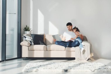 Mutlu baba ve kızı evde dizüstü bilgisayarla vakit geçiriyorlar..