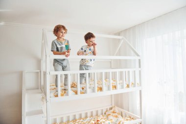 İki küçük çocuk dinleniyor ve yatak odasında birlikte eğleniyorlar..