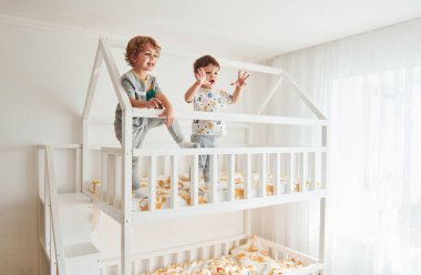 İki küçük çocuk dinleniyor ve yatak odasında birlikte eğleniyorlar..