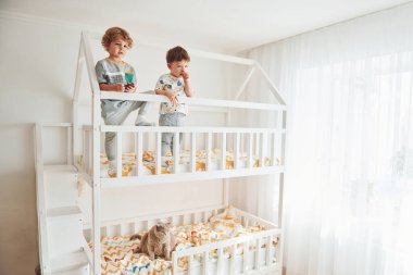 İki küçük çocuk dinleniyor ve yatak odasında birlikte eğleniyorlar..