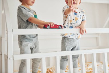 İki küçük çocuk dinleniyor ve yatak odasında birlikte eğleniyorlar..