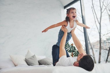 Happy father with his daughter have fun at home together.