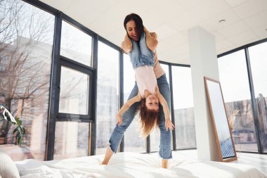 Genç anne ve kızı hafta sonunu yatakta geçiriyorlar..