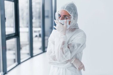 Kötü, yorgun ve depresif hissediyorum. Laboratuvar önlüklü, koruyucu gözlüklü ve maskeli kadın doktor portresi..