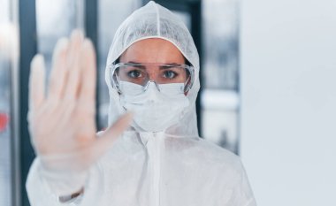 Virüs işaretini durdur. Laboratuvar önlüklü, koruyucu gözlüklü ve maskeli kadın doktor portresi..