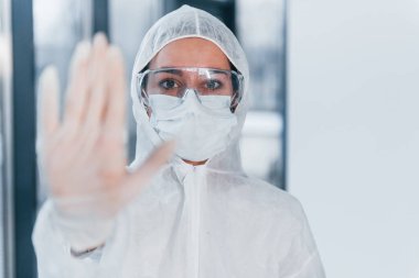 Virüs işaretini durdur. Laboratuvar önlüklü, koruyucu gözlüklü ve maskeli kadın doktor portresi..