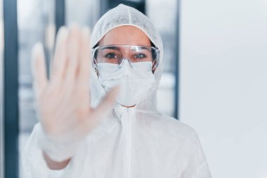 Virüs işaretini durdur. Laboratuvar önlüklü, koruyucu gözlüklü ve maskeli kadın doktor portresi..