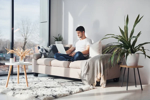 Man White Shirt Jeans Sitting Bed Laptop Indoors — Foto de Stock
