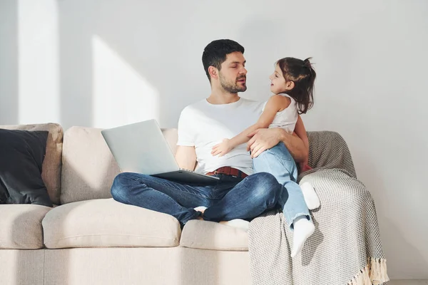 Mutlu baba ve kızı evde dizüstü bilgisayarla vakit geçiriyorlar..