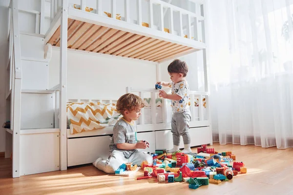 Dos Niños Pequeños Divierten Interior Del Dormitorio Con Juego Construcción —  Fotos de Stock