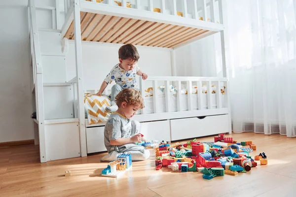 Two Little Boys Have Fun Indoors Bedroom Plastic Construction Set — Stok fotoğraf