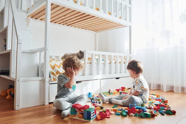 Two Little Boys Have Fun Indoors Bedroom Plastic Construction Set — Stockfoto