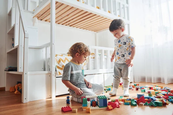 Two Little Boys Have Fun Indoors Bedroom Plastic Construction Set — Stockfoto