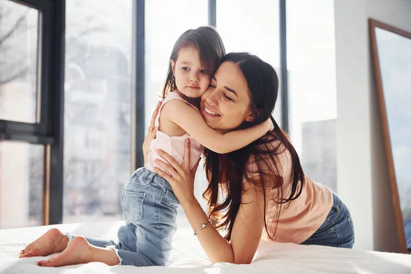 Giovane Madre Con Sua Figlia Che Abbraccia Sul Letto — Foto Stock