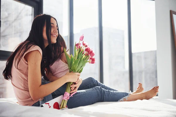 Birbirinize sarılın. Kızı annesini tatille tebrik eder ve bir buket çiçek verir..