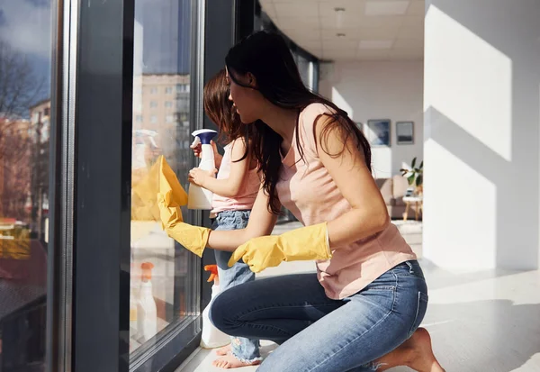 Woman Her Daughter Cleaning Windows Using Spray Together — Zdjęcie stockowe