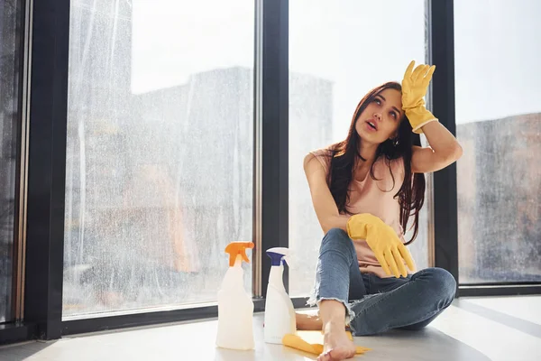 Tired Woman Sits Window Sill Bottles Cleaning Spray Gloves — Zdjęcie stockowe