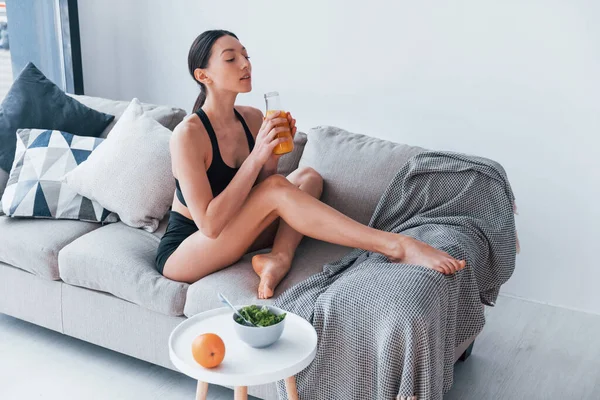 Young Woman Slim Body Shape Sportswear Sits Sofa Eats Healthy — Φωτογραφία Αρχείου
