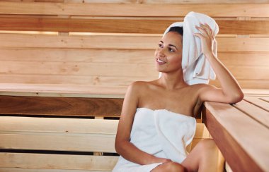 Genç ve güzel bir kadın saunada dinleniyor. Bakım kavramı.
