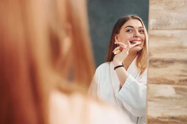 Krásná Mladá Žena Stojící Koupelně Blízkosti Zrcadla Čistí Zuby — Stock fotografie