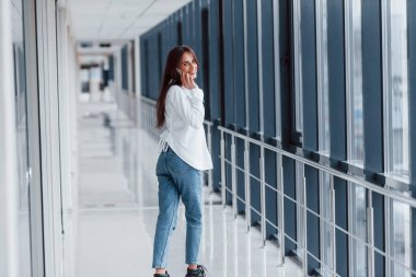 Beyaz gömlekli esmer, modern havaalanında ya da gündüz vakti telefonla konuşan..