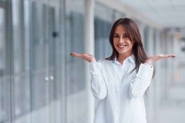 Modern havaalanında ya da gündüz vakti koridorda beyaz gömlekli esmer bir kadın..