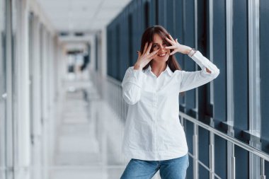 Modern havaalanında ya da gündüz vakti koridorda beyaz gömlekli esmer bir kadın..