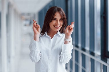 Modern havaalanında ya da gündüz vakti koridorda beyaz gömlekli esmer bir kadın..