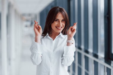 Gündüz vakti modern havaalanında ya da koridorda yürüyen beyaz gömlekli esmer kadın..