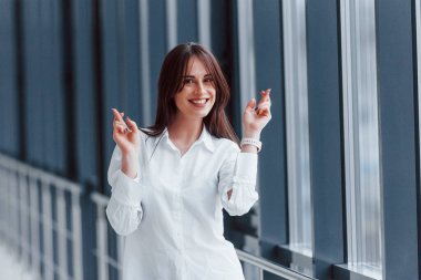 Gündüz vakti modern havaalanında ya da koridorda yürüyen beyaz gömlekli esmer kadın..