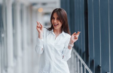 Modern havaalanında ya da gündüz vakti koridorda beyaz gömlekli esmer bir kadın..