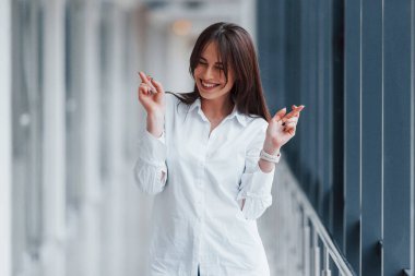 Modern havaalanında ya da gündüz vakti koridorda beyaz gömlekli esmer bir kadın..