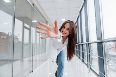 Modern havaalanında ya da gündüz vakti koridorda beyaz gömlekli esmer bir kadın..