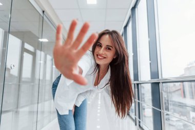 Modern havaalanında ya da gündüz vakti koridorda beyaz gömlekli esmer bir kadın..