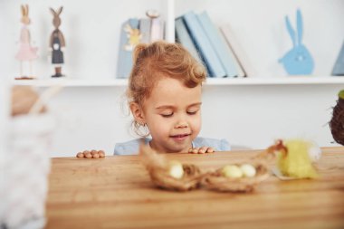 Paskalya tatilini evde yumurta yiyerek kutlayan tatlı küçük bir kız..
