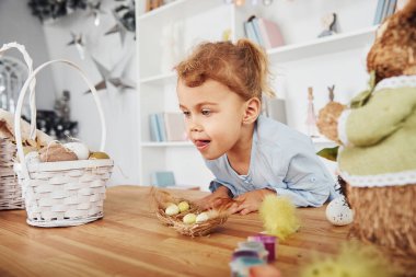 Paskalya tatilini evde yumurta yiyerek kutlayan tatlı küçük bir kız..