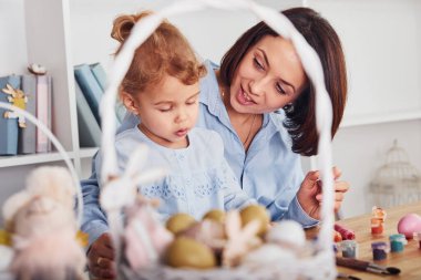 Anne ve kızı birlikte Paskalya bayramını kutluyorlar. Yumurta boyuyor..