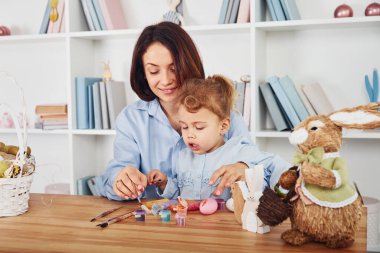 Anne ve kızı birlikte Paskalya bayramını kutluyorlar. Yumurta boyuyor..