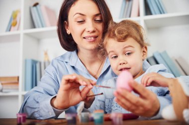 Anne ve kızı birlikte Paskalya bayramını kutluyorlar. Yumurta boyuyor..