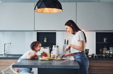 Annesinin, küçük kızıyla mutfakta yemek hazırlarken ki görüntüsü..