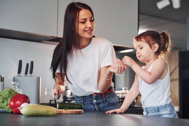 Anne ve küçük kızı mutfakta sebze doğruyor..