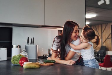 Anne ve küçük kızı mutfakta sebze doğruyor..