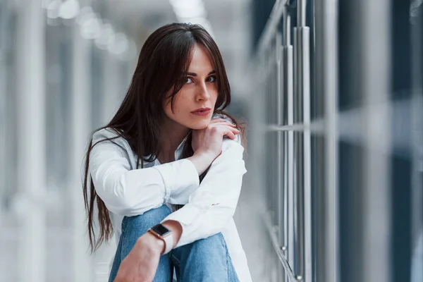 Brunette White Shirt Sits Indoors Modern Airport Hallway Daytime — стокове фото